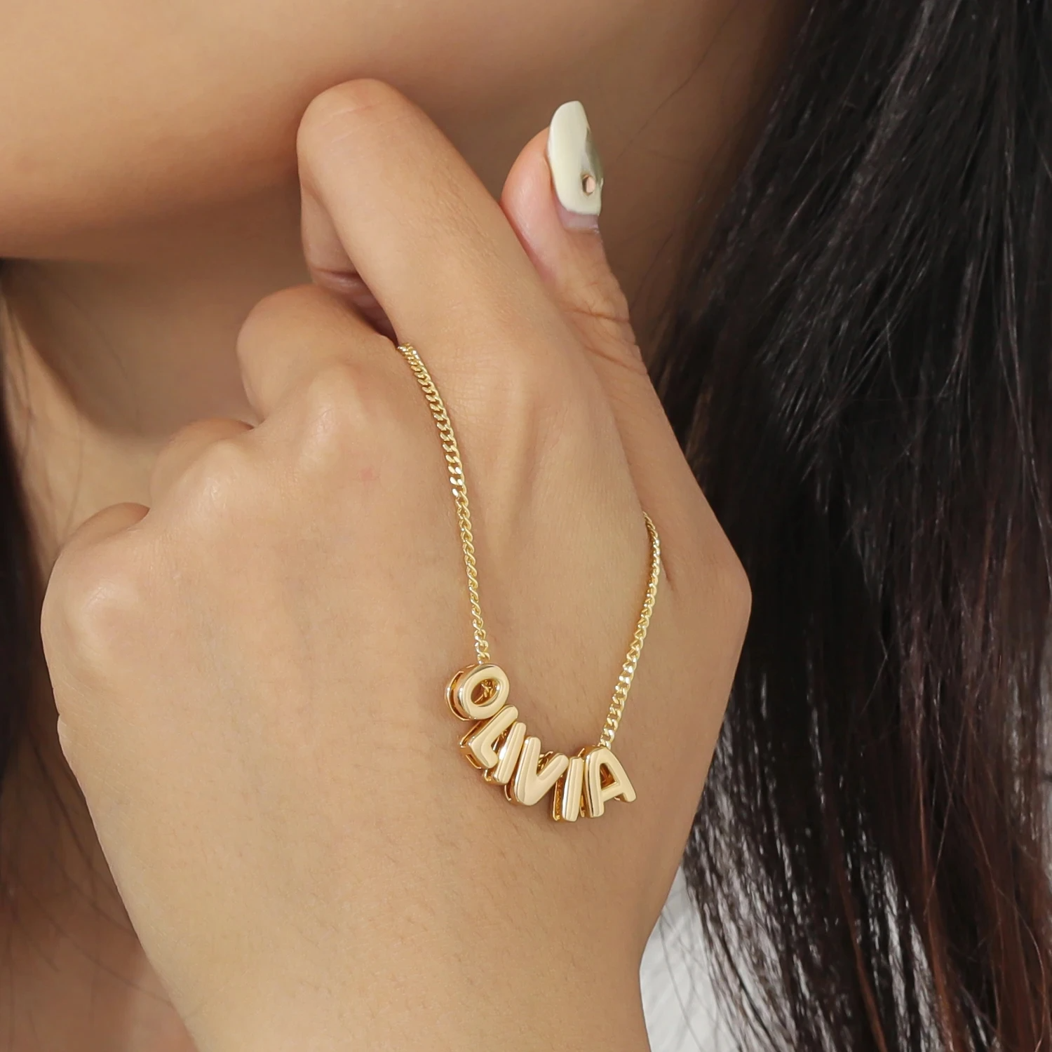 Model holding the Classic Bubble Letters Name Necklace, showcasing its stylish design and bubble-letter details.