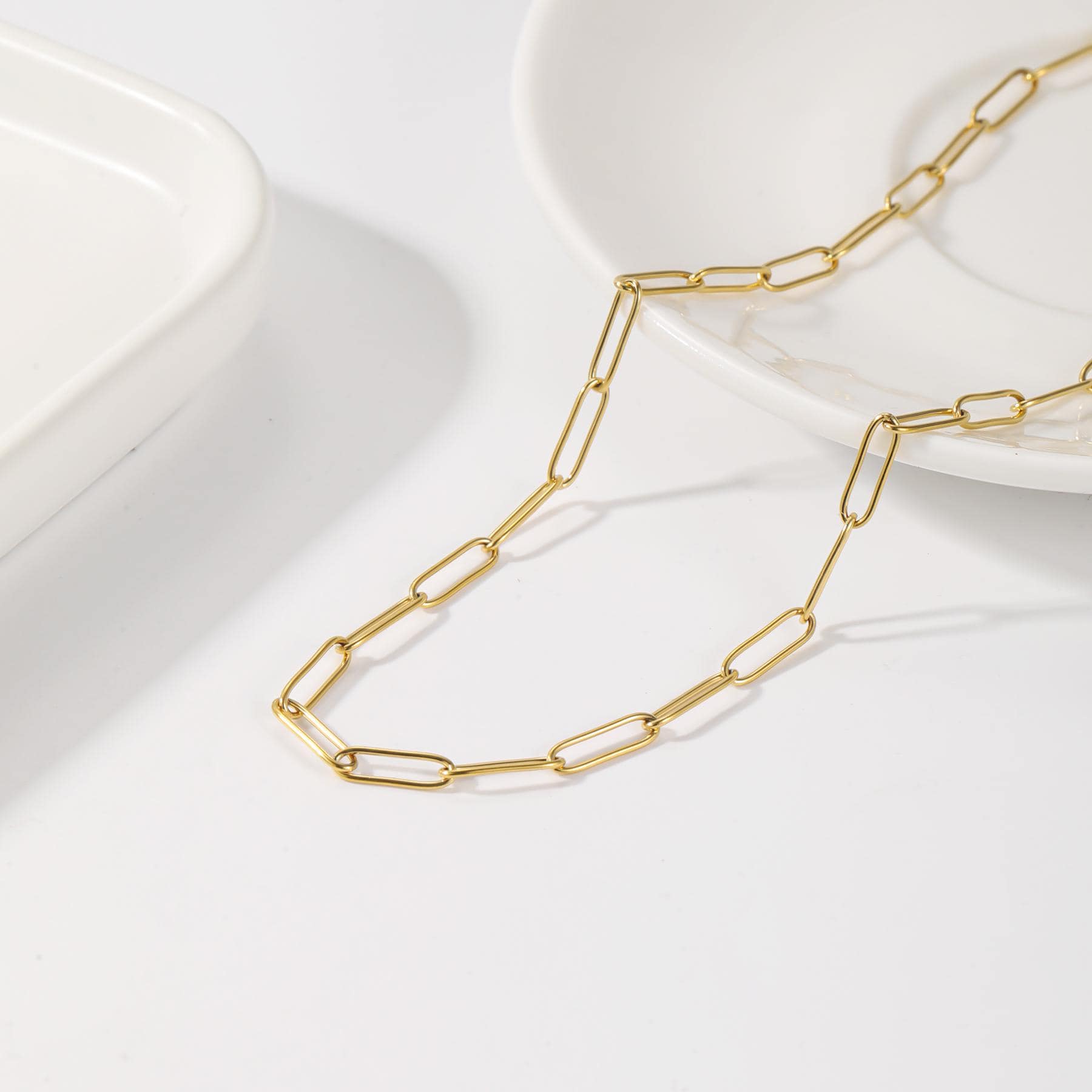 May include: A gold chain necklace with a simple, linked design. The chain is made of small, oval-shaped links.